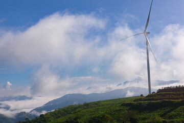 Renewable energy wind turbines windmill isolated on the beautiful blue sky, white clouds and on the tea fields in Da Lat city, Lam Dong, Viet Nam