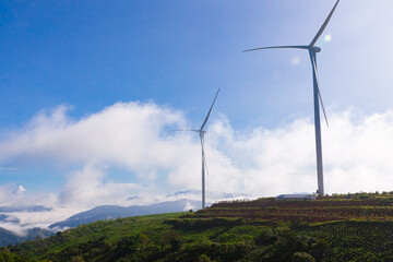Renewable energy wind turbines windmill isolated on the beautiful blue sky, white clouds and on the tea fields in Da Lat city, Lam Dong, Viet Nam
