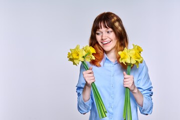 Portrait of young woman with bouquet of yellow flowers, copy space