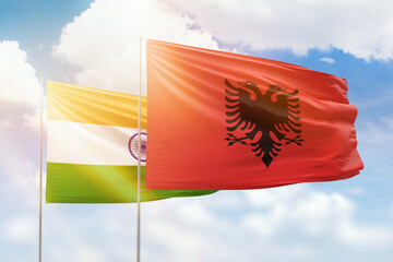 Sunny blue sky and flags of albania and india