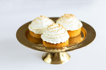 Cakes with white cream on a golden stand. White background
