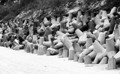 Concrete breakwaters made of tetrapod blocks. Breakwater on the beach and dunes. Concrete blocks on the beach.