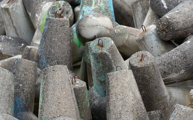 Concrete breakwaters made of tetrapod blocks. Breakwater on the beach and dunes. Concrete blocks on the beach.