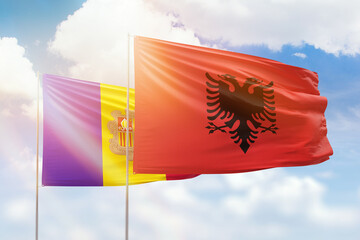 Sunny blue sky and flags of albania and andorra