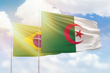 Sunny blue sky and flags of algeria and brazil