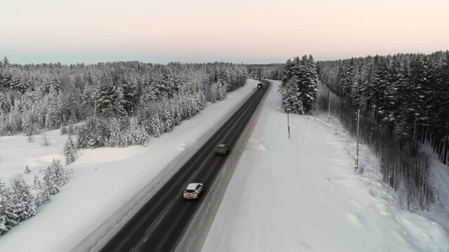 Top view of cars driving on a snow covered icy road exploring the local scenery in winter.