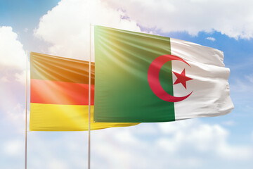 Sunny blue sky and flags of algeria and germany