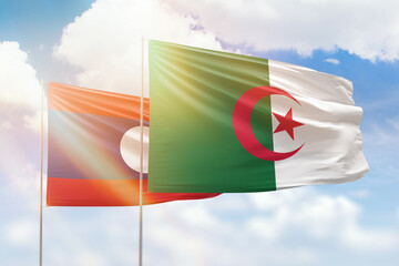 Sunny blue sky and flags of algeria and laos