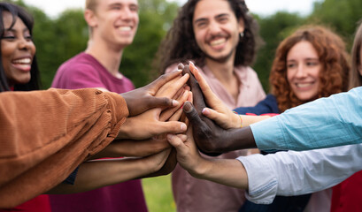 Multiracial happy young people shaking hands - University students celebrating a International Volunteer Day