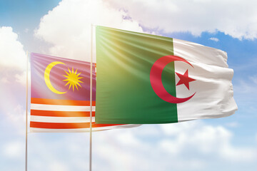 Sunny blue sky and flags of algeria and malaysia