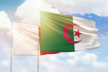 Sunny blue sky and flags of algeria and malta