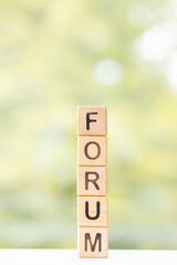 Forum word is written on wooden cubes on a green summer background Closeup of wooden elements