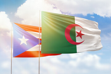 Sunny blue sky and flags of algeria and puerto rico