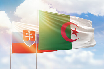 Sunny blue sky and flags of algeria and slovakia