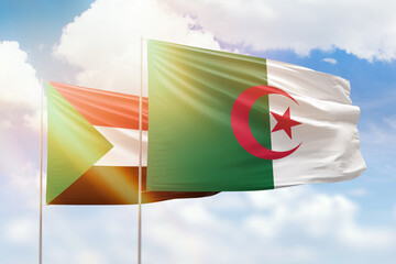 Sunny blue sky and flags of algeria and sudan