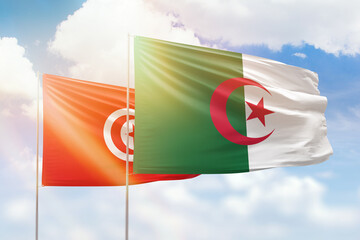 Sunny blue sky and flags of algeria and tunisia