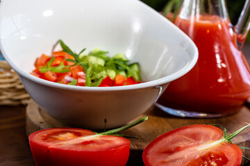 Tasty appetizing summer tomato soup puree gazpacho with tomatoes and cucumbers served in bowl