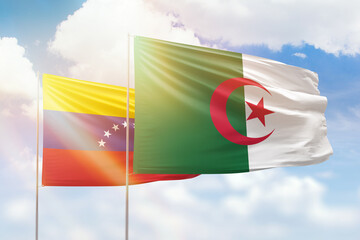 Sunny blue sky and flags of algeria and venezuela
