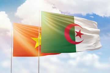 Sunny blue sky and flags of algeria and vietnam