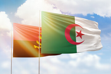 Sunny blue sky and flags of algeria and angola