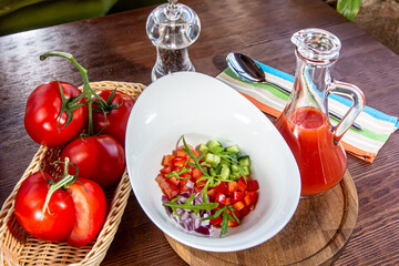 Tasty appetizing summer tomato soup puree gazpacho with tomatoes and cucumbers served in bowl