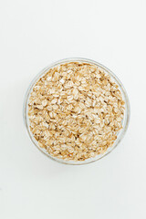 Organic Rolled Oats in a glass bowl on white background