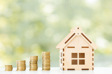 Coin is placed in a model wooden house. concept the growth of finance. planning savings money of...