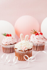 Sweets with pink cupcakes, bunny and air balloons, vertical card with colorful dessert