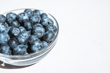 Blue blueberries in bowl, food background with copy space