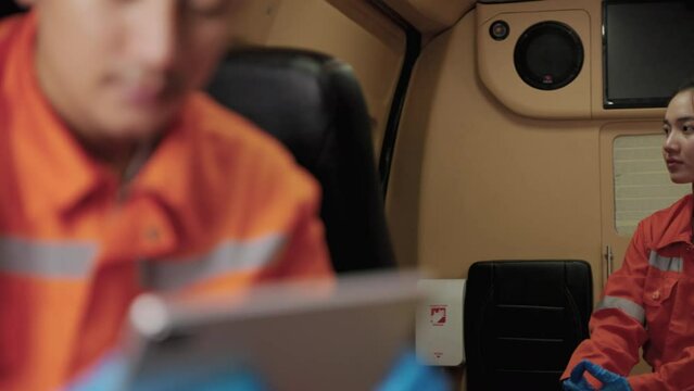 Asian paramedic worker is sitting in a car to pick up a patient with a tense expression on his face and anxious