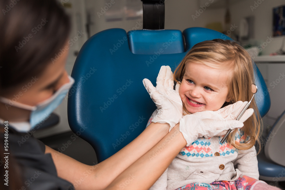 Wall mural examination, treatment teeth children. medical checkup oral cavity with instruments. dental hands, child in clinic. Cute girl smiling stomatology. Happy kid in dentist chair. concept health, medicine