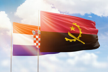 Sunny blue sky and flags of angola and croatia