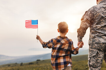 Excited child   with american flag holding his father's hand reunited with family