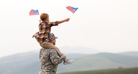 Excited child sitting with american flag on shoulders of father reunited with family
