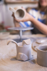 woman working a handmade ceramic cup in her workshop