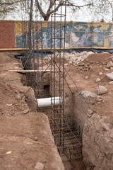 metal columns placed to be filled with cement to build the foundation of a house