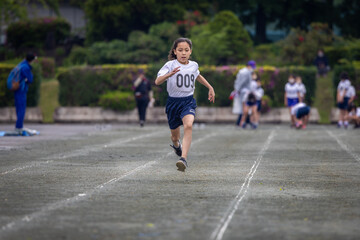 Fototapeta premium Young girl sprinting in 100-meter race.