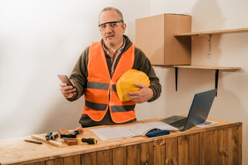 Contractor construction engineer reviewing the development of the work and talking by cell phone with the supplier.