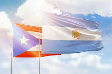 Sunny blue sky and flags of argentina and puerto rico