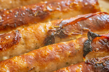 Piping hot sausages on baking tray closeup