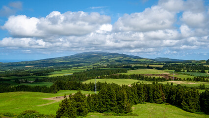 Fototapeta na wymiar Beautiful green landscape on a cloudy blue sky in São Miguel, Azores Islands, Portugal. Nature amazing Green Landscape of Azores.