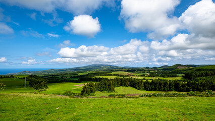 Fototapeta na wymiar Beautiful green meadow on a cloudy blue sky in São Miguel, Azores Islands, Portugal. Nature amazing Green Landscape of Azores.