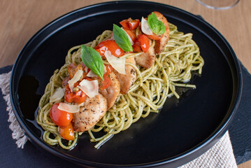 Cherry tomatoes with chicken pasta in a black plate