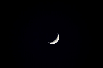 Obraz na płótnie Canvas Crescent moon at 24 percent seen from the community of Madrid, in Spain on Wednesday night, June 4, 2022