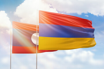 Sunny blue sky and flags of armenia and laos