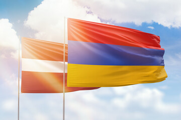 Sunny blue sky and flags of armenia and latvia