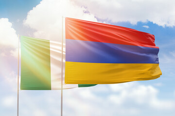 Sunny blue sky and flags of armenia and nigeria