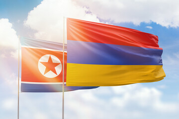 Sunny blue sky and flags of armenia and north korea