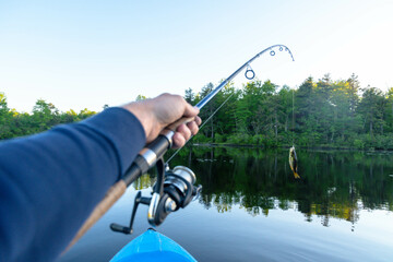 Kayak fishing, fresh catch fish, leisure hobby activity, summer theme.