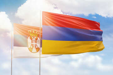 Sunny blue sky and flags of armenia and serbia